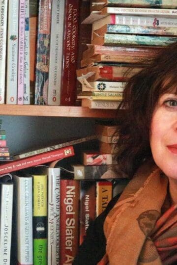 Cheryl, Queen of Markets in front of her bookshelves.