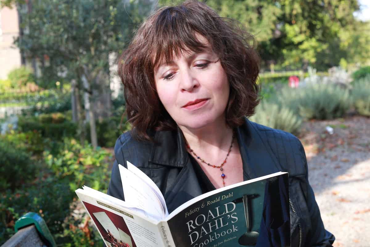 Cheryl Queen of Markets, holding a book.