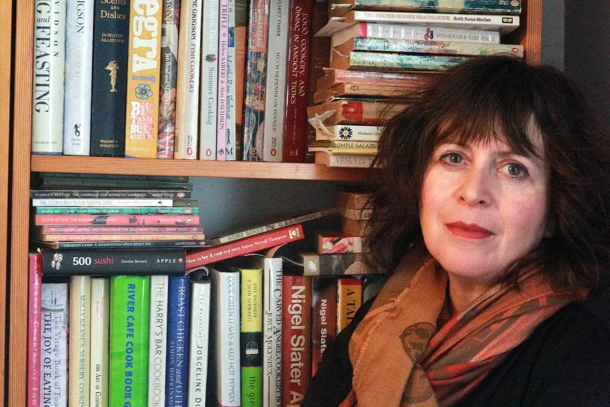 Cheryl in front of her bookshelves.