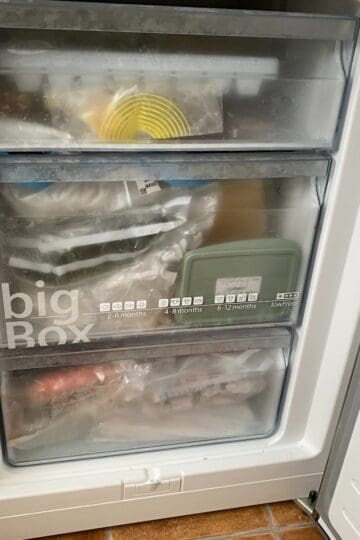 Vacuum-sealed frozen food in a freezer drawer for long-term storage.
