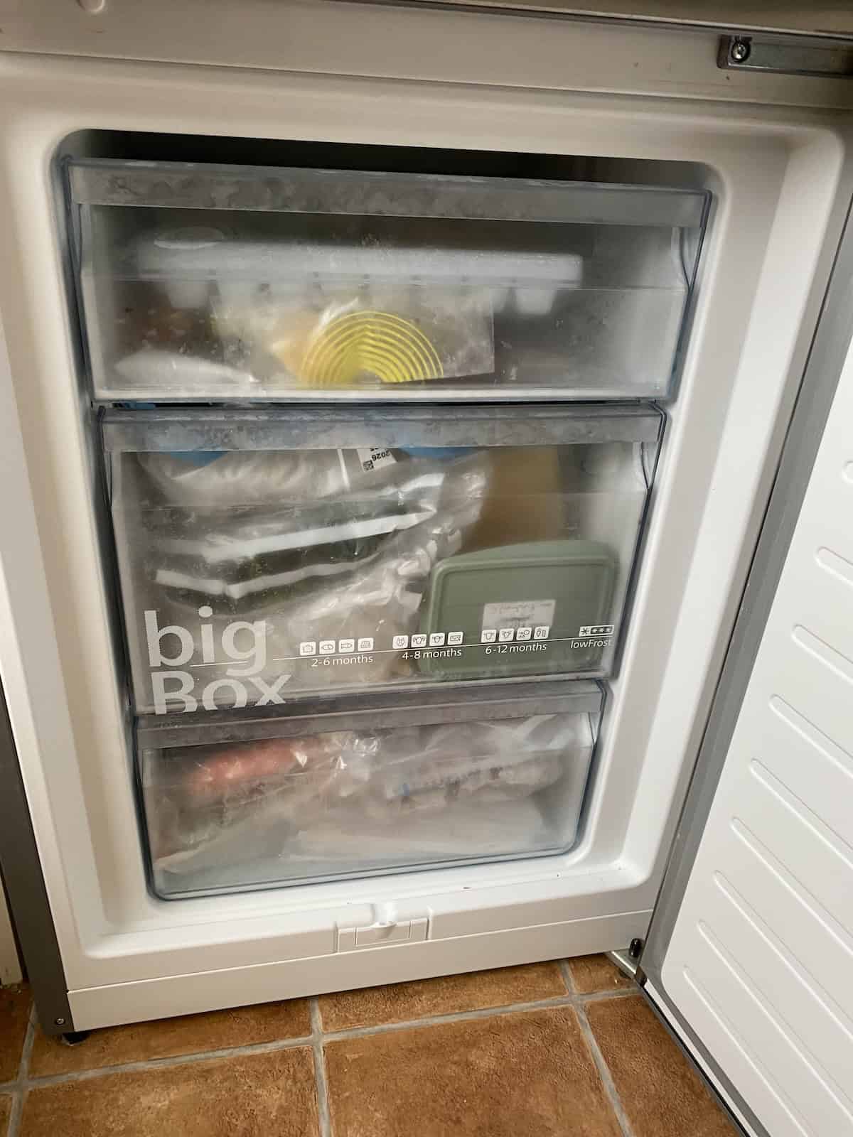 Vacuum-sealed frozen food in a freezer drawer for long-term storage.