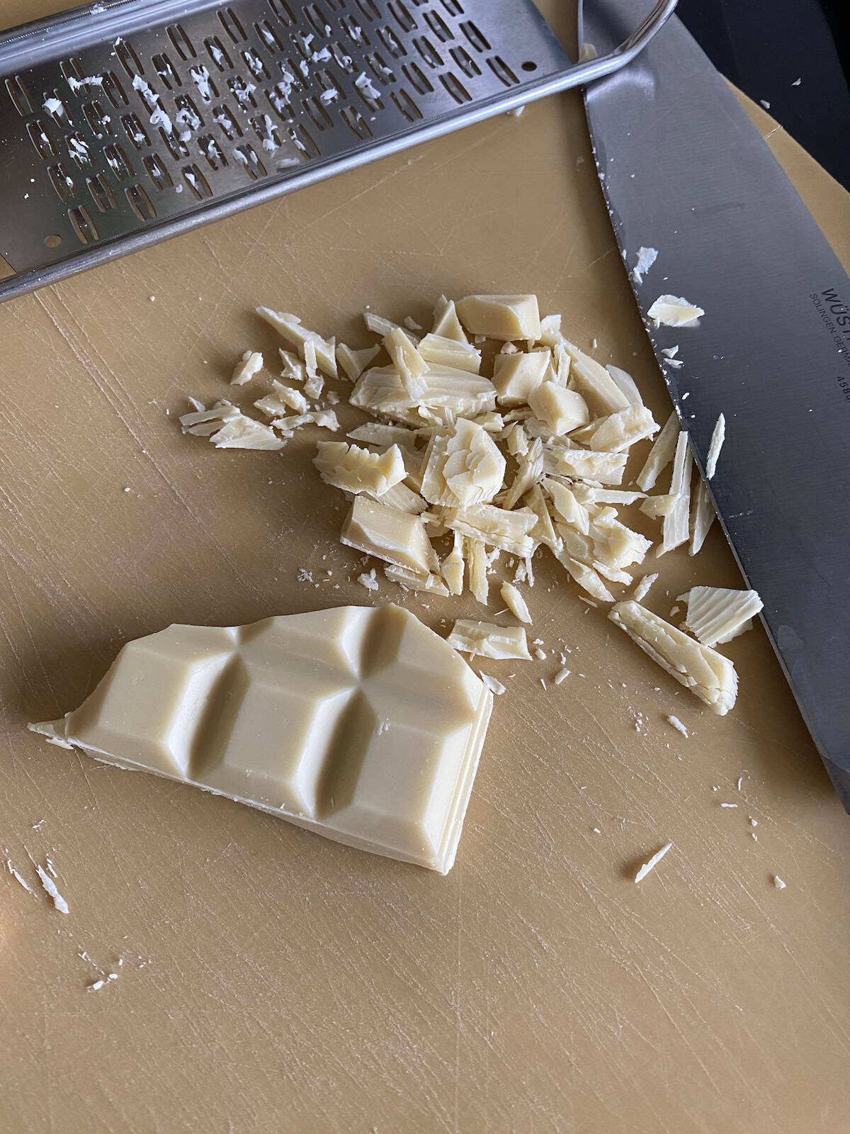 White chocolate on top of a chocolate traybake. White chocolate cut into rough chunks.