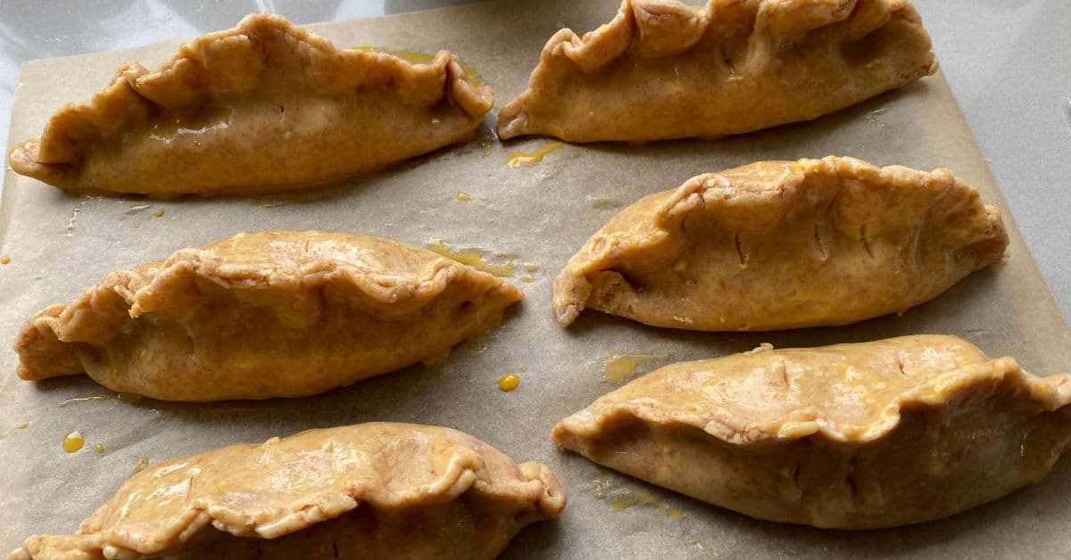 Vegetable Pasties on a baking tray. Unbaked vegetable and lentil pasties on a baking tray.