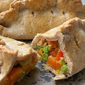 Vegetable and Lentil Pasties sliced in two showing the filling inside.