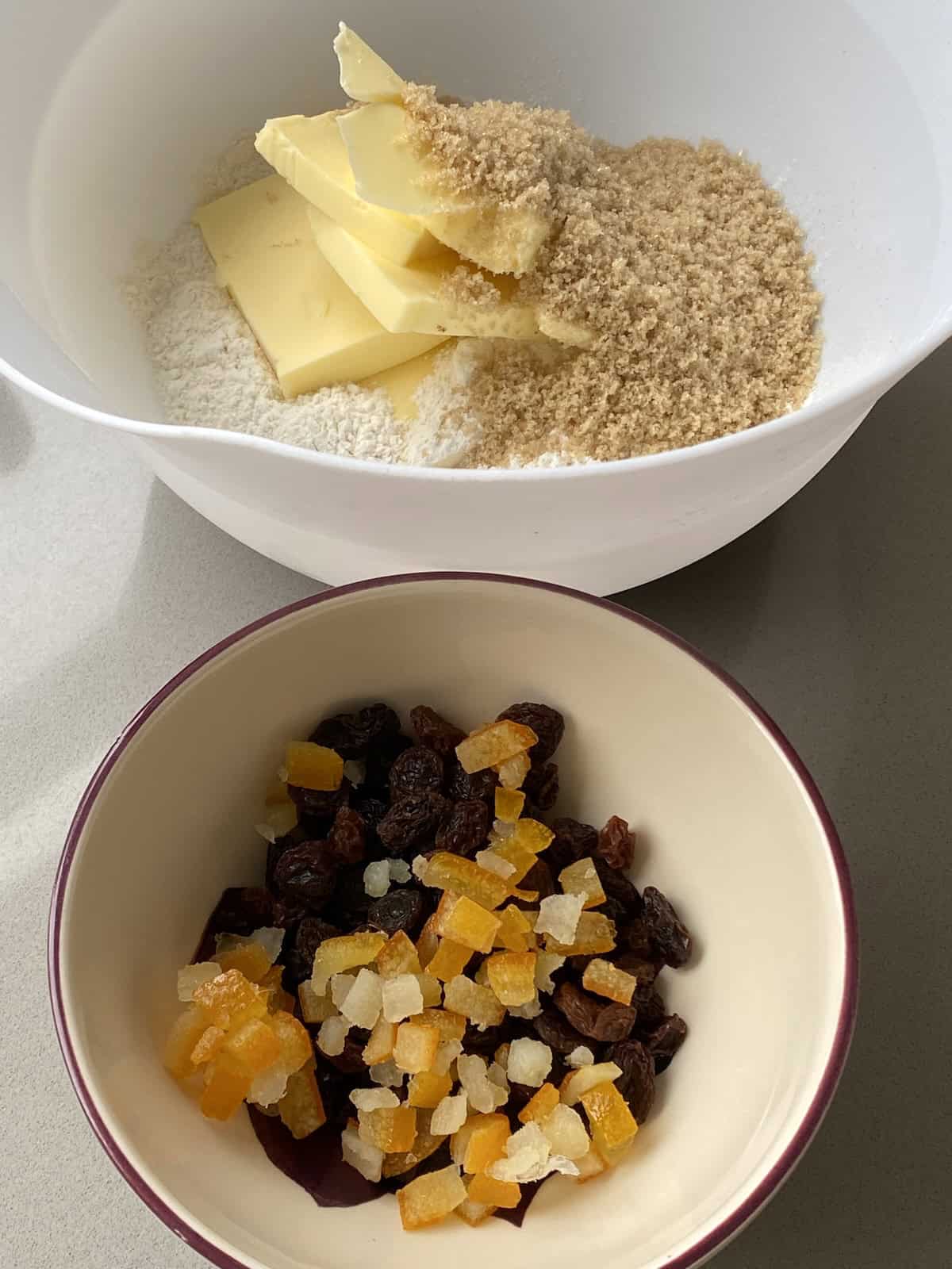 mixed dried fruit in a small dish, butter and flour in a mixing bowl.