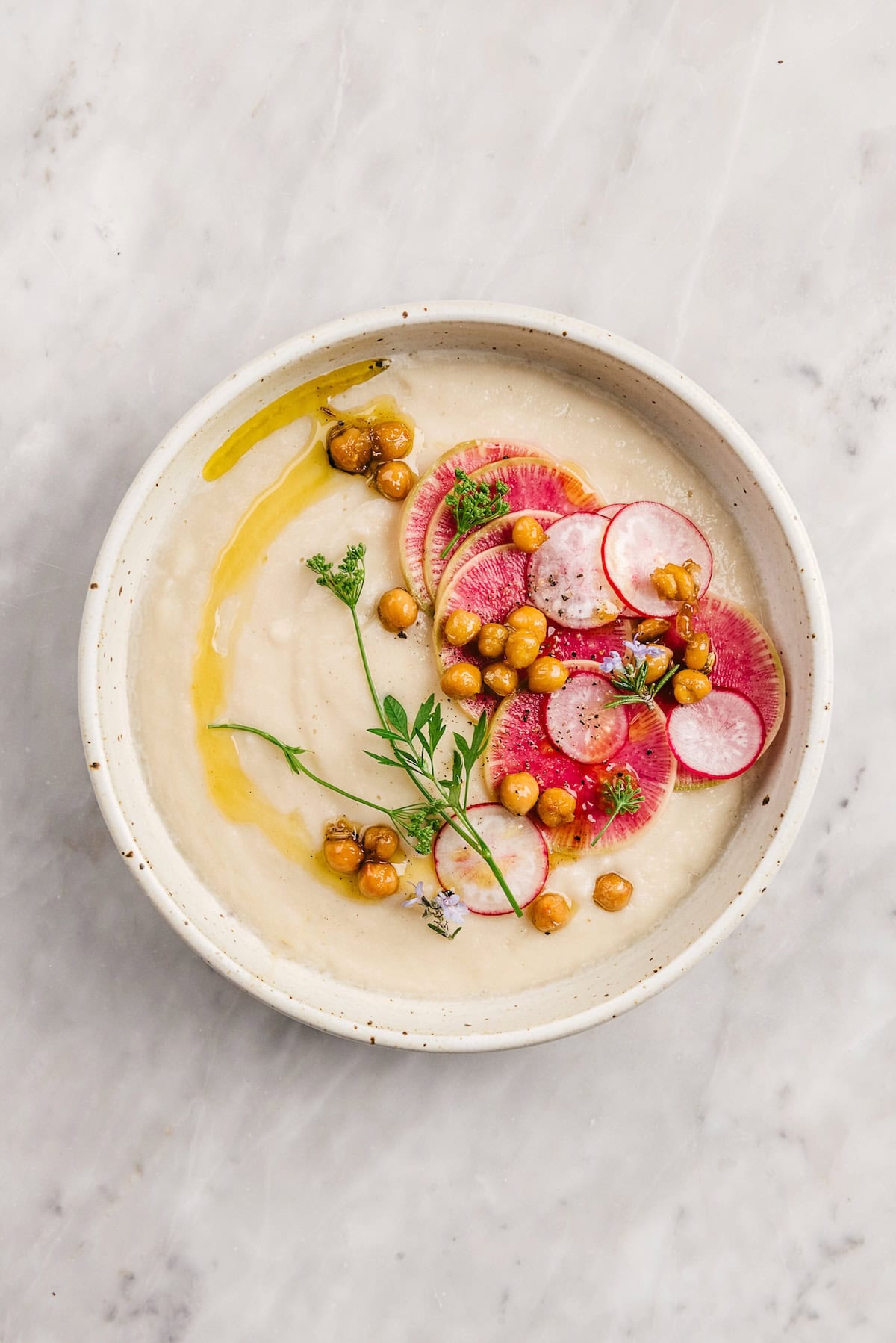 CREAMY CAULIFLOWER SOUP WITH CRISPY SPICED CHICKPEAS, RADISH AND HERBS