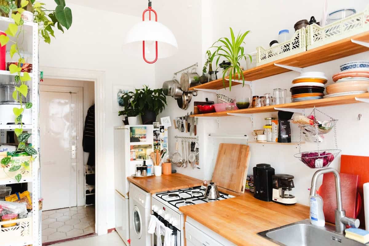 Kitchen with open wooden shelving and white walls. Devan Grimsrud's kitchen.