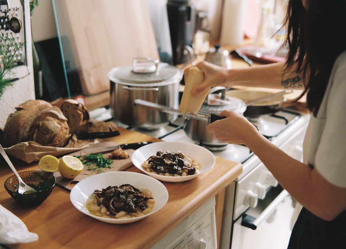 Grating cheese onto plates of food. Devan grating cheese onto platers of food.