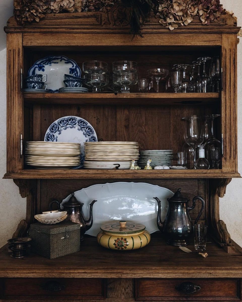 Wooden dresser with plates and crockery on the shelves.